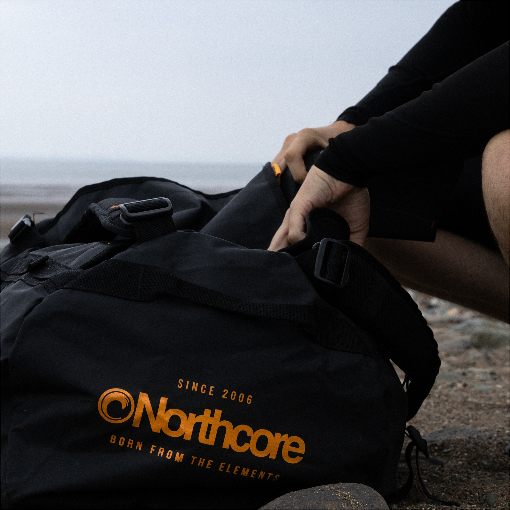 2025 Northcore Duffle Bag 85L NOCO123BB - Black / Orange